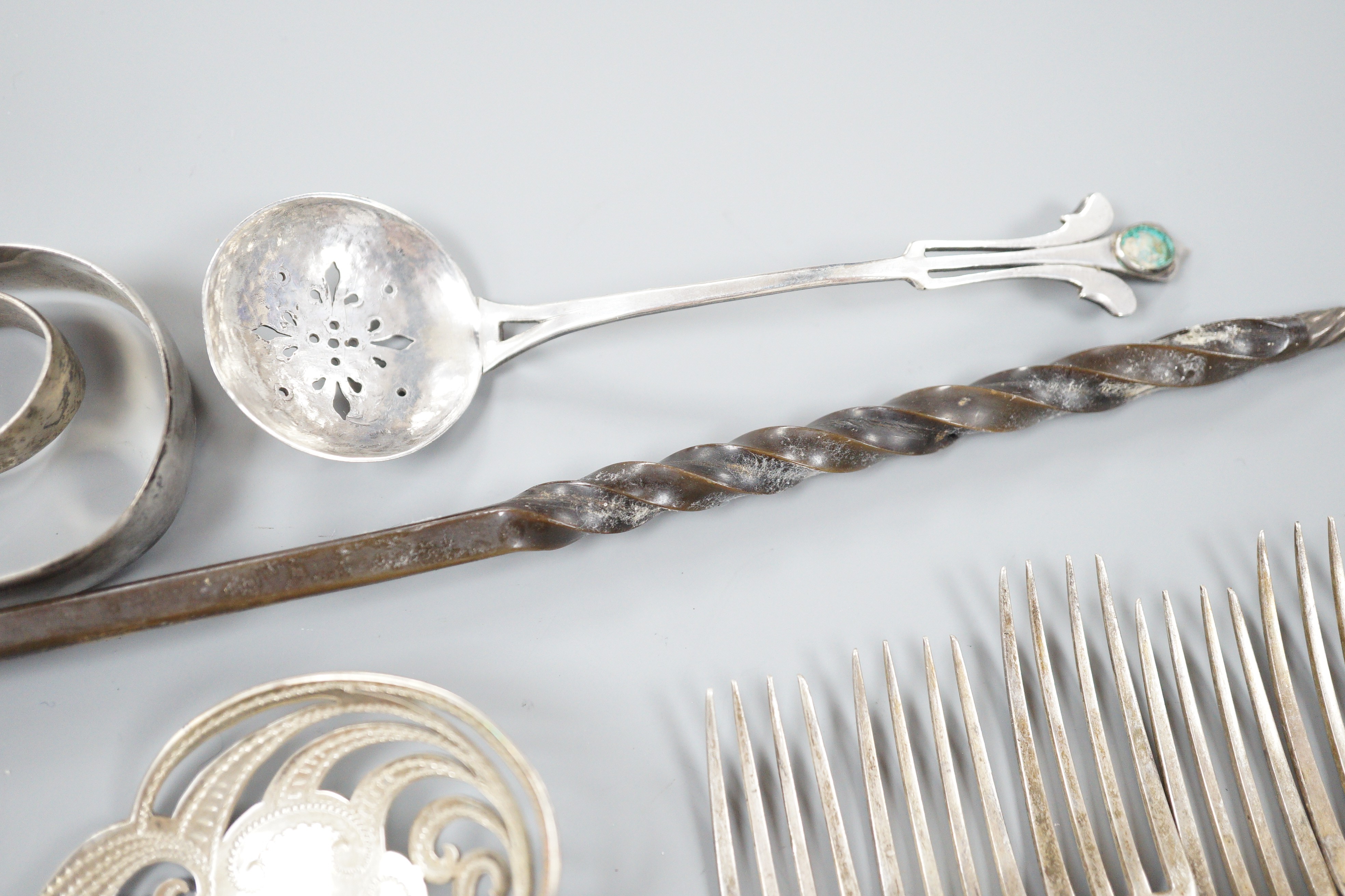 A pair of Victorian silver scrolling knife rests, George Adams, London, 1859, 10.4cm, a pair of pierced silver spoons, two pairs of silver sugar tongs, a part set of Victorian silver dessert eaters(6 & 5), a toddy ladle